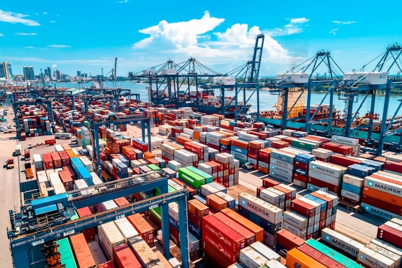 Stacked shipping containers in port representing supply chain logistics